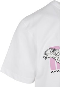 Hvit bomulls T-skjorte med et svart leopardmotiv og en rosa blokk bak, med sjakkmønsterdetaljer langs bunnen.