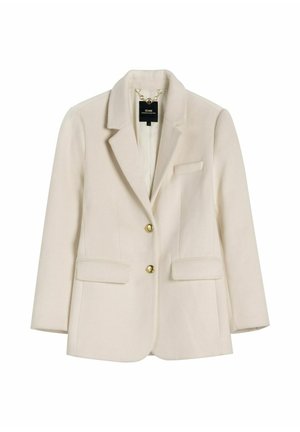 Kremowa dopasowana marynarka z wyciętymi klapami, dwoma złotymi guzikami, kieszeniami z klapkami oraz łańcuszkiem wewnątrz przy kołnierzu.