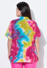 Camicetta a maniche corte con motivo tie-dye nei vivaci colori blu, rosa e giallo, realizzata in un tessuto texture e con dettagli al collo.
