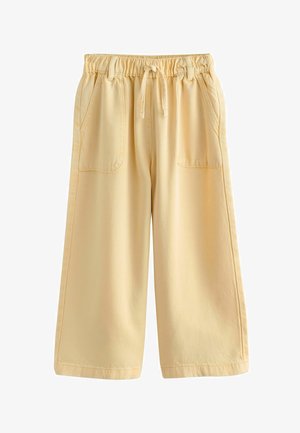 Hellgelbe Hosen mit weitem Bein, elastischem Bund, Kordelzug und aufgesetzten Taschen vorne, vor weißem Hintergrund dargestellt.