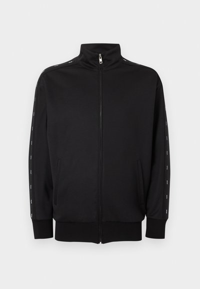 Μαύρο αθλητικό μπουφάν με φερμουάρ, γιακά όρθιο, πλαϊνές τσέπες, ριμπ τελειώματα και λευκές διακεκομμένες ρίγες κατά μήκος των μανικιών.