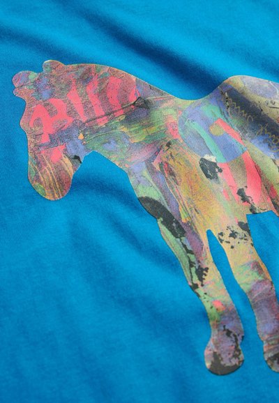 T-shirt en coton bleu présentant une silhouette multicolore de cheval avec des motifs abstraits en tons de rose, vert et orange.