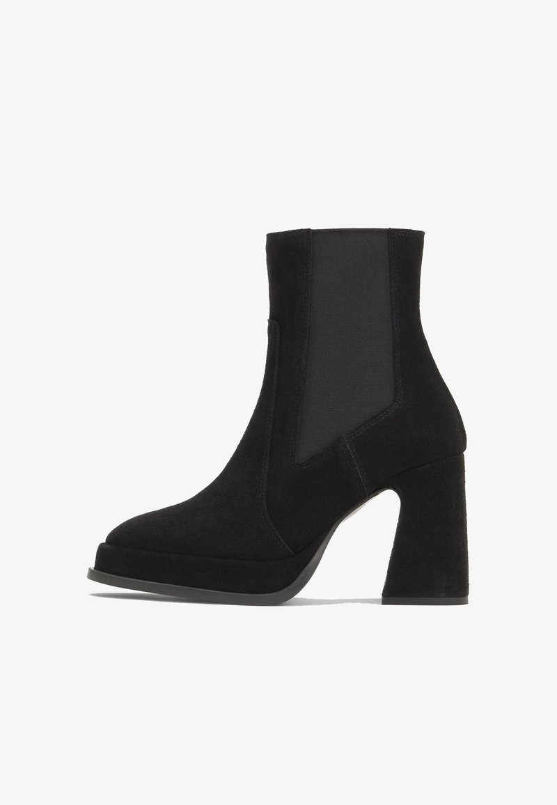 Bottine noire en daim avec panneau latéral élastique et talon bloc, conçue pour la mode féminine et un usage décontracté.