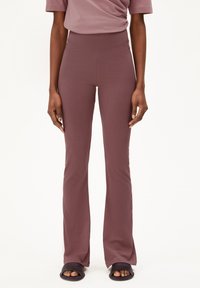 Mauve flared leggings with a high waistband, made of smooth, stretchy fabric, paired with dark slide sandals.