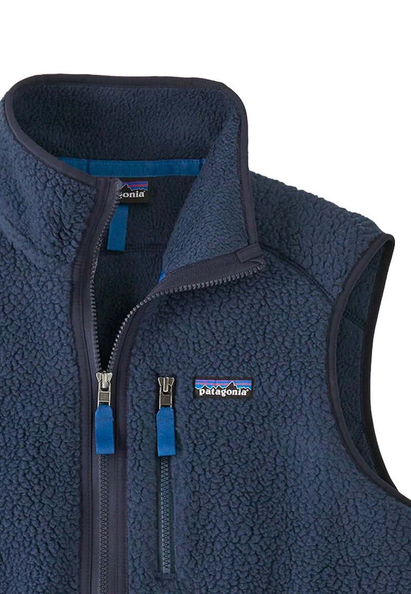 Gilet in pile di colore blu navy con colletto alto, zip frontale e tasca sul petto; presenta una superficie testurizzata e zip in blu contrastante.