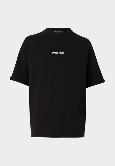 Svart t-skjorte med korte ermer og en liten hvit "roberto cavalli" logo sentrert på brystet, med rund hals og rullede ermekanter.