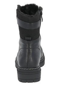 Botas de tobillo de cuero negro con forro de pelo sintético, cierre de cremallera y acento de correa ancha. Suela de goma chunky con dibujo texturizado para mayor agarre.
