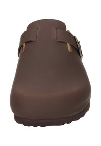 Bruine leren klompen met twee verstelbare bandjes, een afgeronde neus en een getextureerde zool, met een gladde buitenkant en minimale hardware.