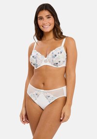 Sujetador blanco de encaje y bragas a juego con bordado floral. Presenta paneles de malla transparente y un delicado lazo en las bragas.