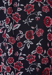 Blommig tyg med röda och vita blommor p å en mörk marin bakgrund. Blad och virvlande vinrankor skapar ett intrikat mönster. Mjuk textur.