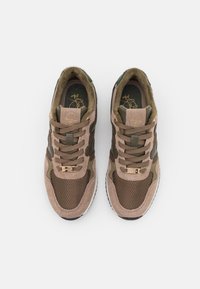 Bruna mocka- och mesh-sneakers med olivgröna accenter, beiga snören och en guldlogotyp på tungan. Texturerad och sportig design.