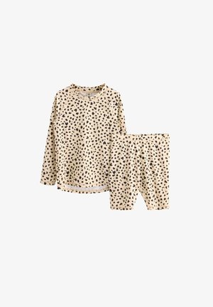 Beige loungewear sæt med langærmet top og shorts, med et mønster af sorte prikker, lavet af blødt bomuldsstof.