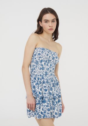 Abito senza spalline con un motivo floreale blu e bianco. Presenta strati arricciati e un corpetto elasticizzato per una silhouette aderente.