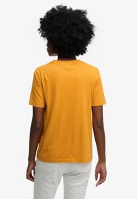 T-shirt met korte mouwen en ronde hals in felgeel katoen. Gladde textuur met een ontspannen pasvorm, voorzien van een rechte zoom en eenvoudig ontwerp.