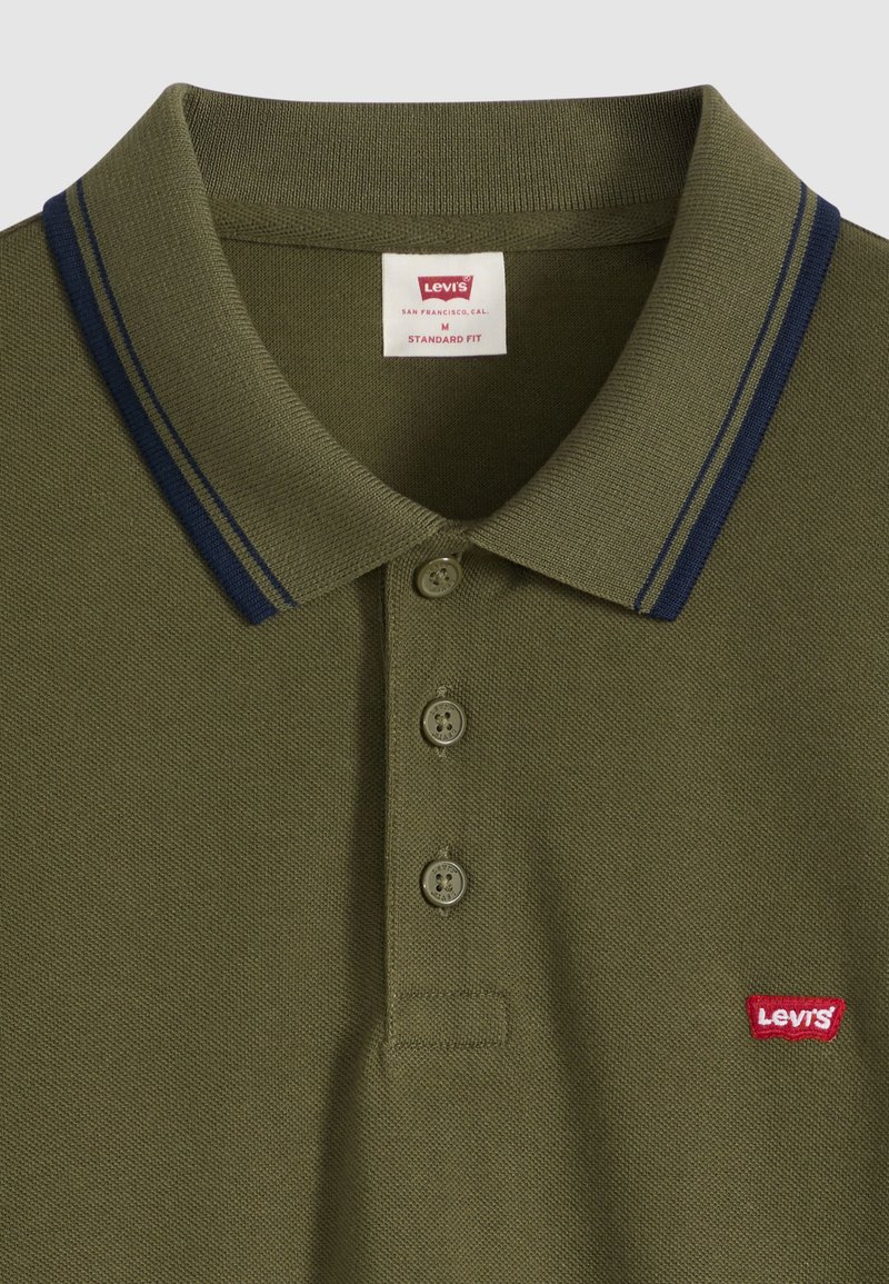 Polo Levi's vert olive avec trois boutons, double rayures bleu marine sur le col et petit logo rouge Levi's sur la poitrine.