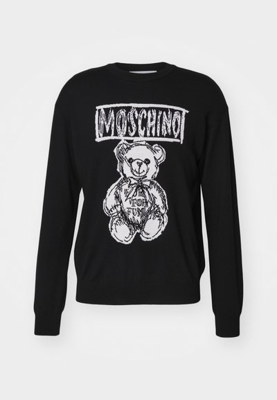 Suéter negro con un gráfico blanco de un oso, con el texto "Moschino" arriba. Textura de punto y mangas largas con puños acanalados.