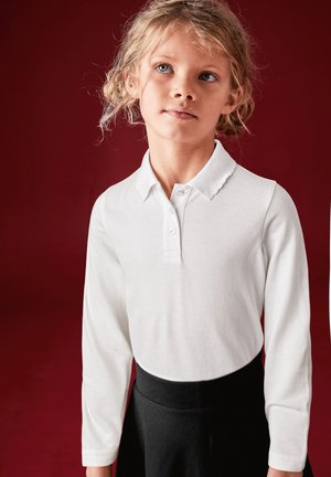 Witte lange mouwen polo shirt met een spits kraag en drie knopen, gecombineerd met een zwarte rok. Glad stof met een casual pasvorm.