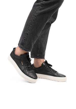 Zapatillas de cuero negras con patrón de reptil texturizado. Suela de goma blanca, puntera redonda y cordones, con un diseño minimalista.