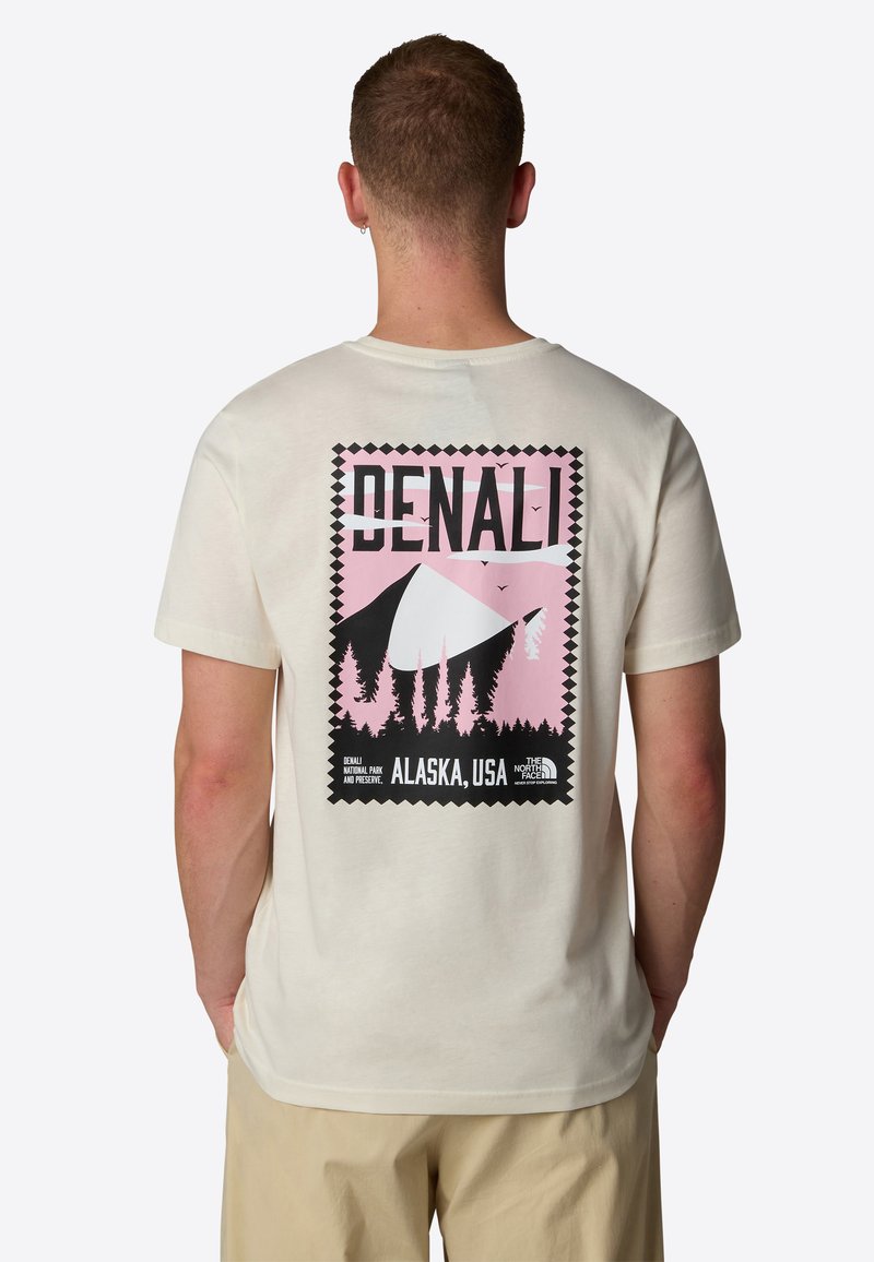 Tričko s krátkým rukávem, krémové barvy, s grafickým potiskem Denali v růžových a černých odstínech, stromy a nápis "DENALI, ALASKA, USA" na zadní straně.