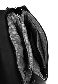 Černý kožený batoh se zipovým uzávěrem, který má více přihrádek vyložených vzorovanou šedou tkaninou.