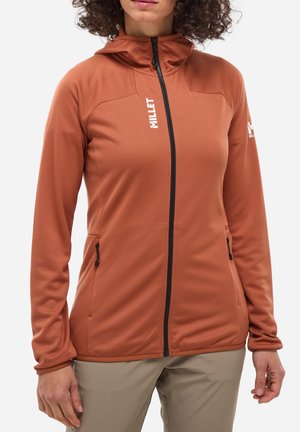 Hoodie léger à manches longues en orange brûlé, confectionné en tissu doux et texturé. Il comprend une fermeture éclair intégrale, deux poches latérales et des accents de logo.