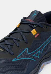 Námornícke športové topánky s textúrovaným zvrškom, modrými akcentmi a živou niťou. Obsahujú mäkkú podrážku a šnurovací dizajn.