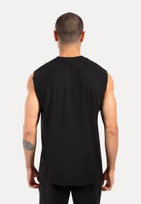 Schwarzes ärmelloses Shirt aus weicher Stoff, mit lässiger Passform und rundem Ausschnitt, von hinten gesehen mit sichtbaren Schulter- und Armdetails.