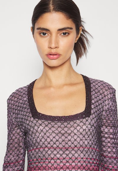 Μωβ πλεκτό μπλουζάκι με τετράγωνη λαιμόκοψη, που διαθέτει υφές και κοσμήματα κατά μήκος του γιακα. Μακριά μανίκια.