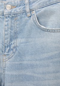 Světle modré džíny z denimu s hladkou texturou, viditelným prošíváním, přední kapsou a knoflíkovým zapínáním v pase.