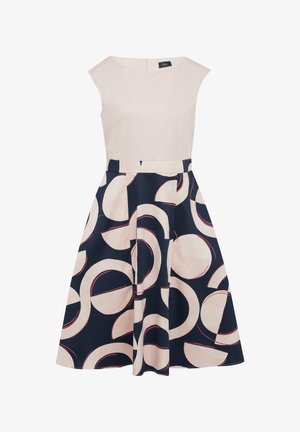 Een mouwloze jurk met een lichtroze bovenstuk en een marineblauwe rok met een cirkelpatroon in lichtroze en rode accenten, tot op de knie.