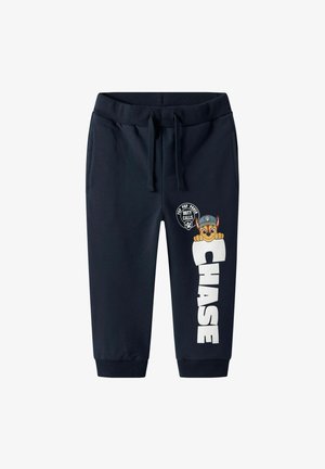 Pantalones jogger en azul marino con cintura elástica, texto impreso en blanco "CHASE" y un apliqué de un perro de dibujos animados con una gorra.