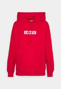 Sudadera roja con capucha, que incluye un bolsillo tipo canguro en la parte frontal, capucha ajustable con cordón, y un logotipo rectangular blanco que dice "LEVI'S" en el pecho.