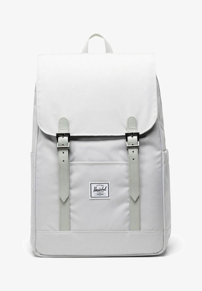 Sac à dos blanc Herschel avec rabat, bretelles à double boucle, poche avant, poches latérales et écusson en tissu avec logo au centre avant.