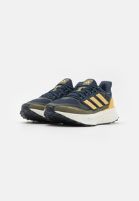 Blue and yellow athletic shoes featuring a textured mesh upper, water-repellent material, and a speckled white sole with a black rubber tread.