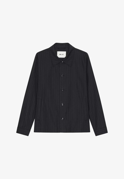 Chemise noire à manches longues boutonnée, rayures fines, col classique et deux poches latérales, étiquette NN.07 à l'intérieur du col.