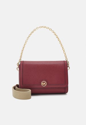 Sac bandoulière en cuir bordeaux avec une bandoulière chaîne dorée et une poignée en tissu beige, orné d'un logo rond doré et d'une surface texturée.