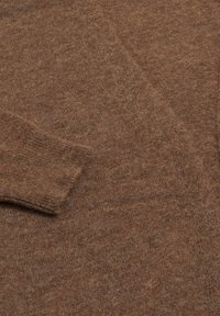 Braun gestrickter Pullover aus einem weichen Stoff, mit einem gerippten Bündchen und einer insgesamt glatten Oberfläche, die die warme Farbe und das gemütliche Design hervorhebt.