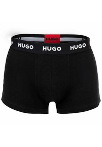 Schwarze Boxershorts aus Baumwolle mit weichem Material; sie haben einen schwarzen Gummibund mit weißen Buchstaben und einem roten Etikett.