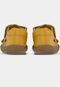 Κίτρινα δερμάτινα παπούτσια με στρογγυλεμένο σχήμα, διαθέτοντας πλευρικές εγκοπές, καφέ λαστιχένιες σόλες και διπλό λουράκι για εύκολη εφαρμογή.