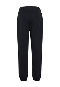 Sorte joggingbukser med skrånende pasform, elastisk taljebånd og manchetter ved anklerne. Fremstillet af blødt stof uden synlige mønstre eller designs.