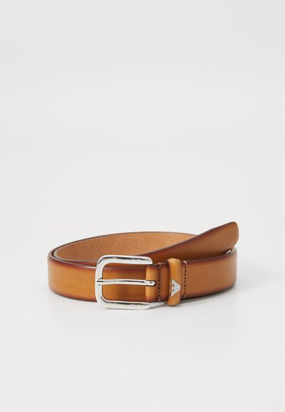 Brown leather belt with a smooth finish, featuring a silver metal buckle and a logo detail on the strap. Classic and sleek design.