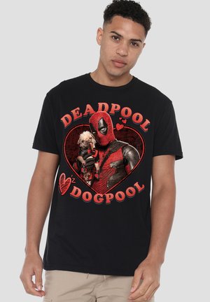 Man wearing black T-shirt with red Deadpool graphic holding a dog, text reads "Deadpool Dogpool" with heart shapes.