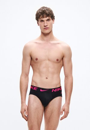 Black men's brief featuring a wide waistband with pink "NIKE" branding, made from smooth fabric with a form-fitting design.