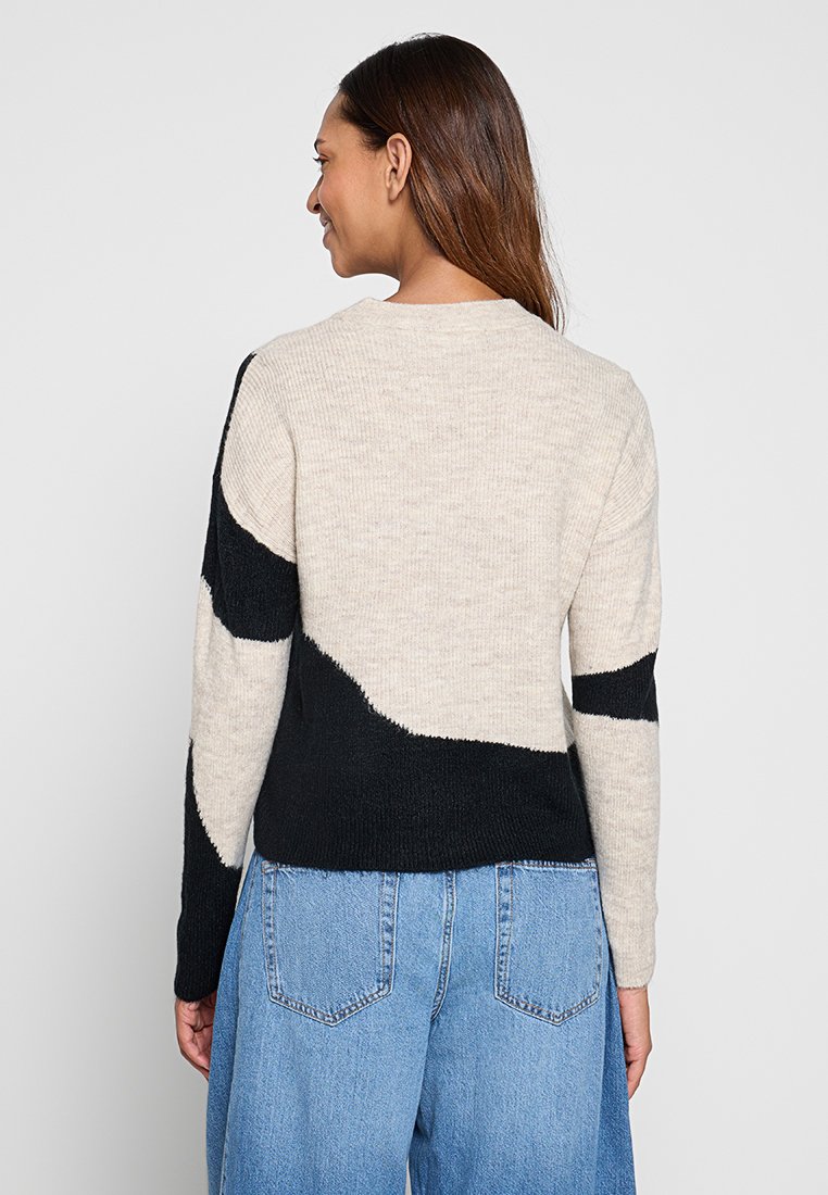 Gehaakte trui met een beige en zwarte kleurvakontwerp. Ribbels met een ronde halslijn en een relaxte pasvorm.