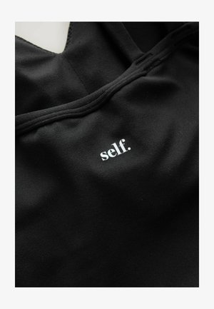 Top sportivo nero con scollo a barca, realizzato in morbido tessuto, con un piccolo logo stampato bianco che recita "self." vicino al centro.
