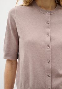 Helles Rosa, kurzärmelige Strickjacke aus weichem Strickstoff, mit Rundhalsausschnitt, Knopfverschluss vorne und gerippten Bündchen. Dezente Texturdetails.