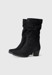 Black mid-calf suede boots with block heels and slightly slouched shafts, featuring textured rubber soles for added grip.