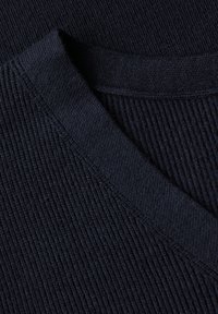 Close-up van donkerblauwe ribgebreide stof met details van een V-hals op een kledingstuk.