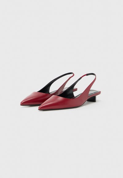 Κόκκινα δερμάτινα slingback παπούτσια με μυτερή μύτη και μικρό, κεκλιμένο τακούνι. Λεία υφή και μινιμαλιστικός σχεδιασμός χωρίς πρόσθετες διακοσμήσεις.