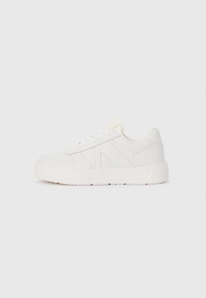 Hvid læder sneaker med lavt skaft, snørelukning foran, syninger og tyk gummisål, vist i profil mod ensfarvet baggrund.
